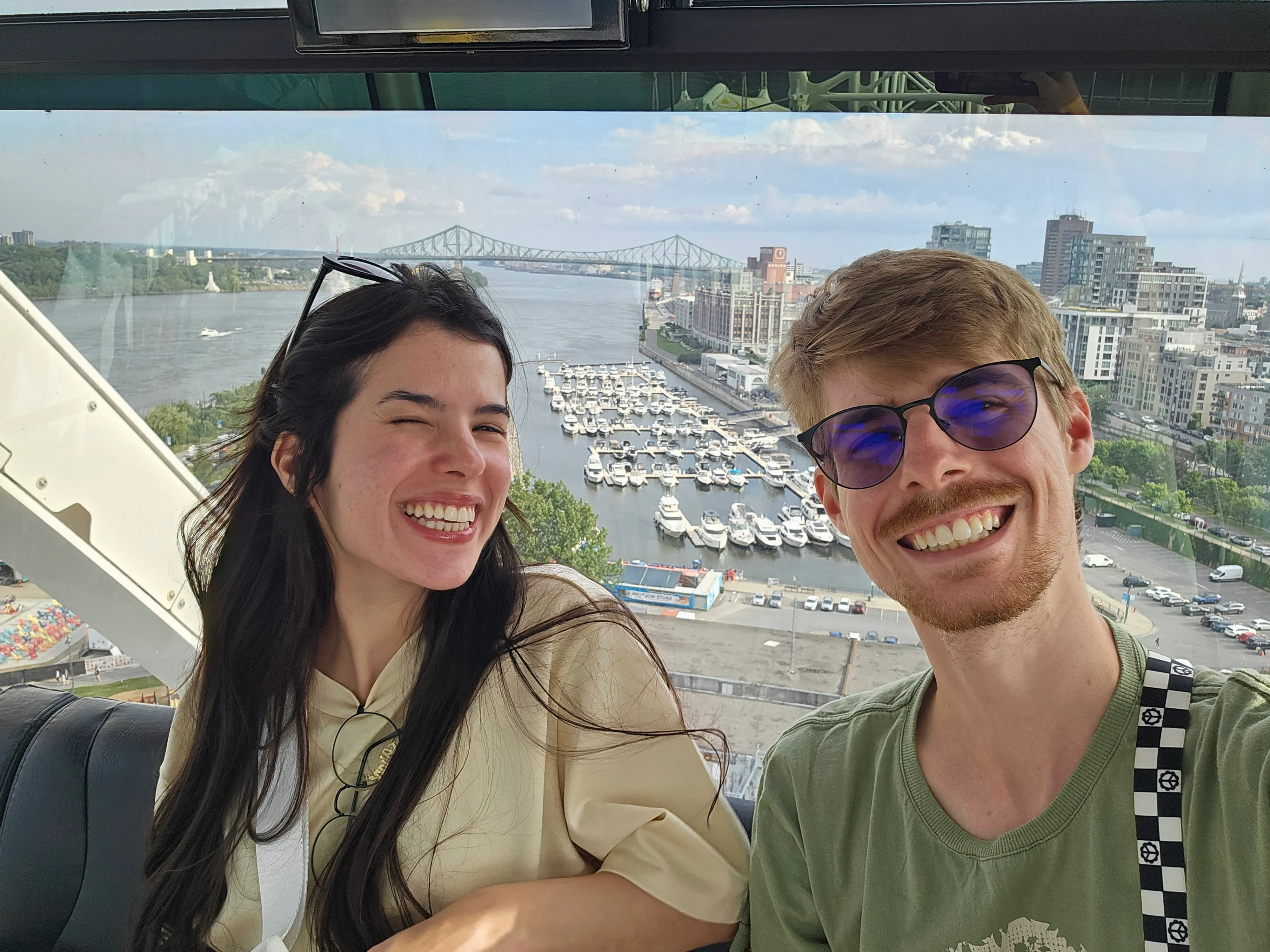 Rafa Audibert and his beautiful fiancée at the top of the Montreal Ferris Wheel looking at the marina and the bridge behind it